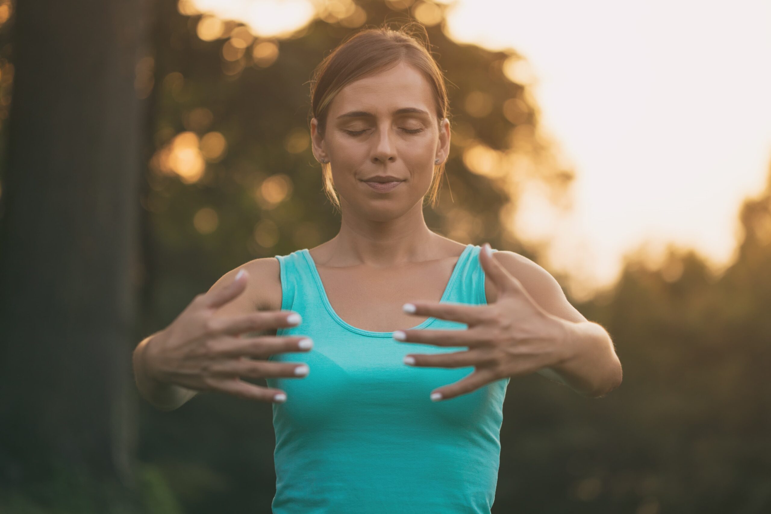 Beautiful woman enjoys exercising Tai Chi in the nature Image is intentionally toned scaled