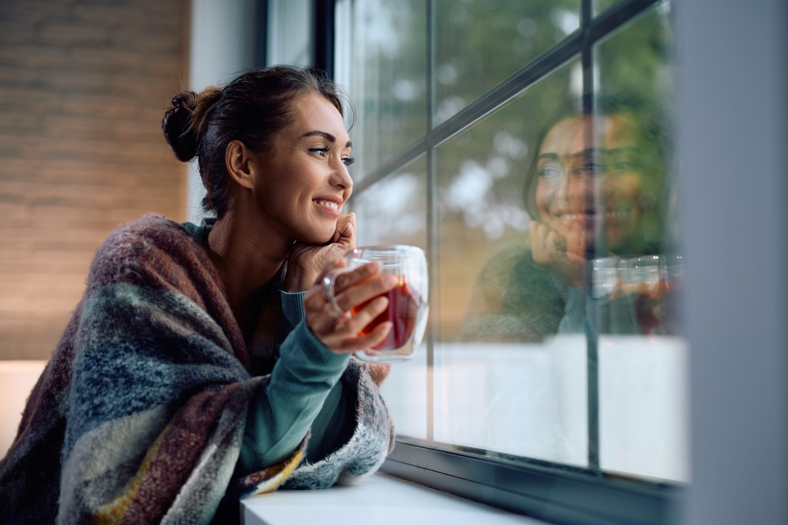 person reflecting quietly during the holidays with a cup of tea in hand