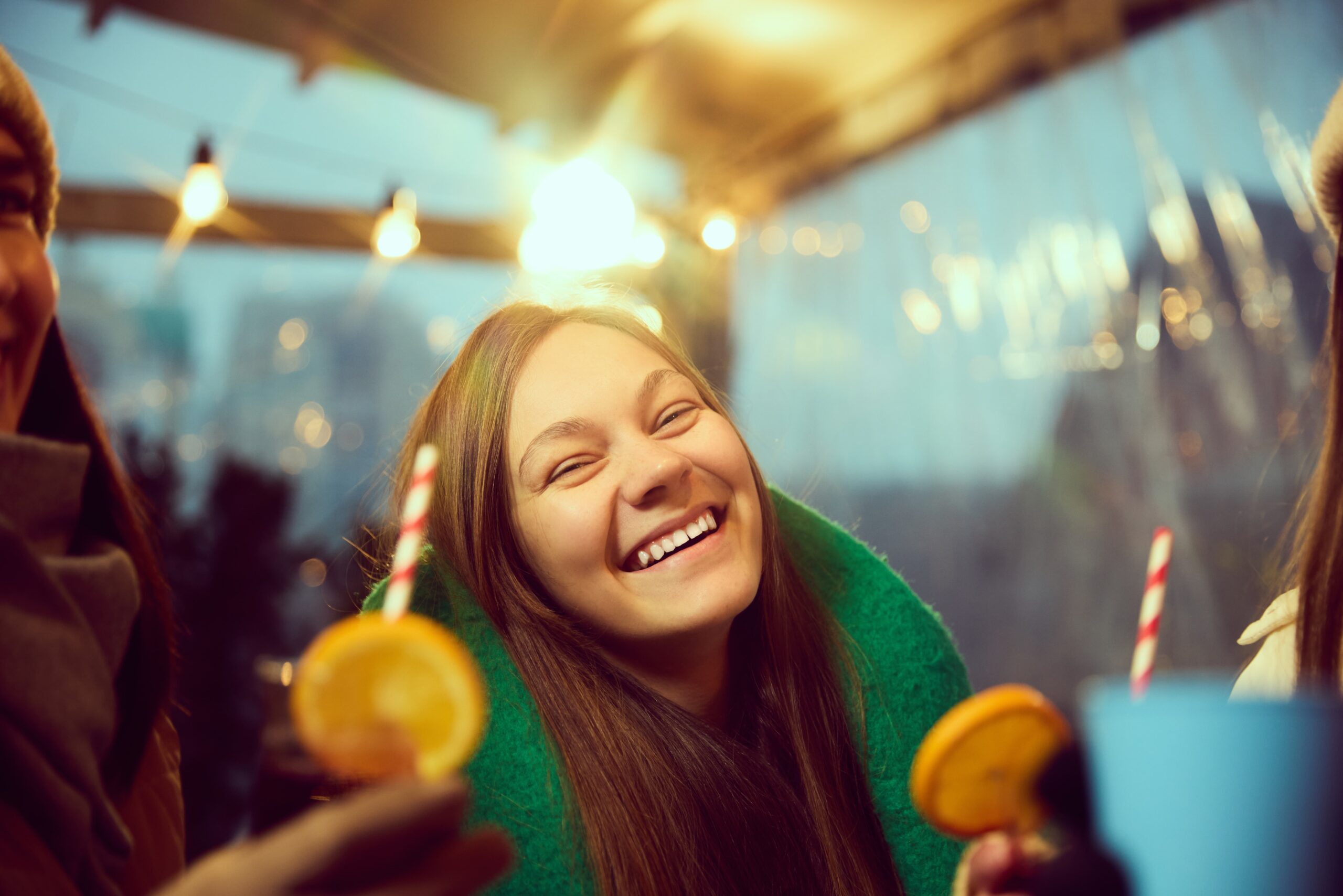 Person celebrating a sober holiday with friends, smiling and holding a non-alcoholic drink